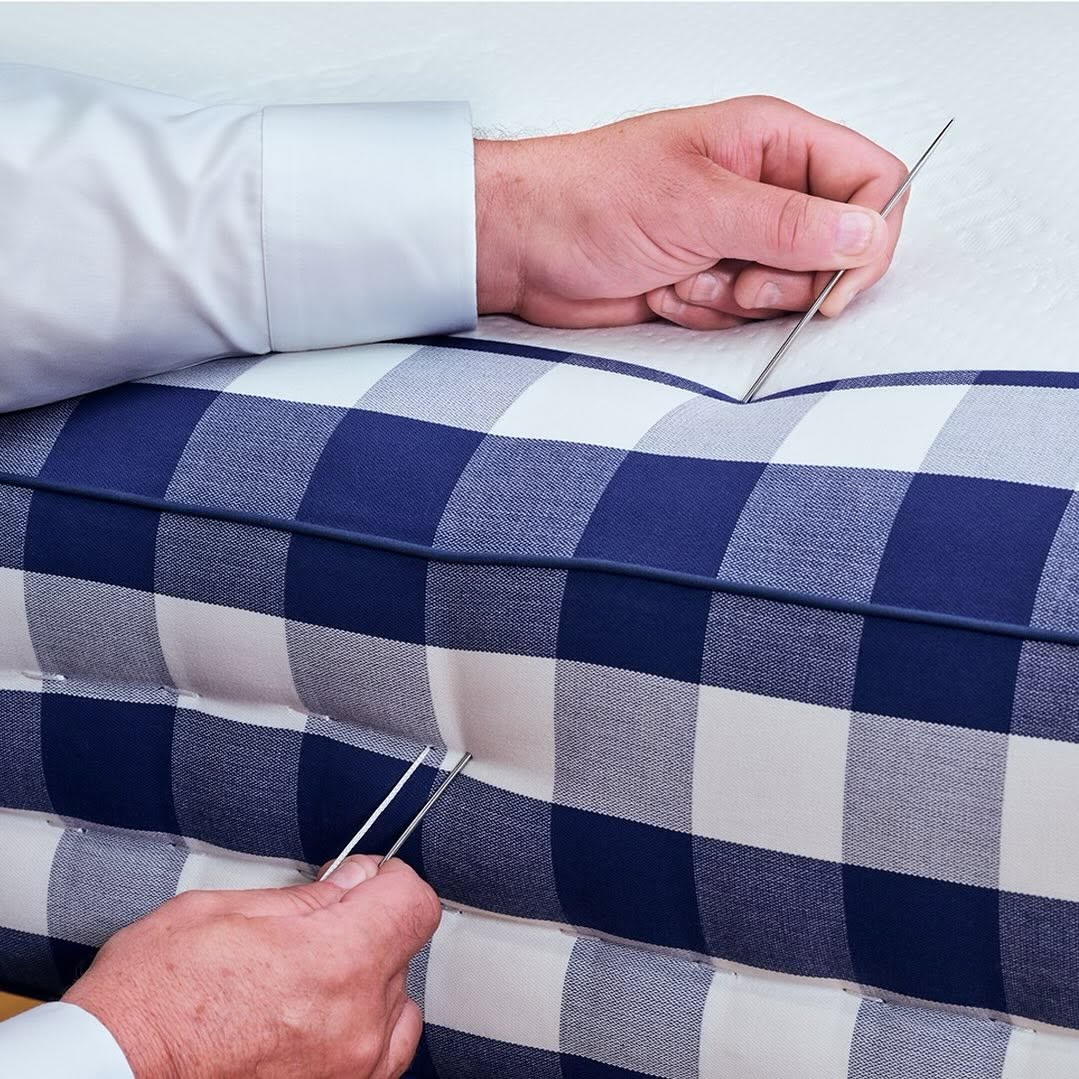 Master artisan hand-tufting layers of natural material